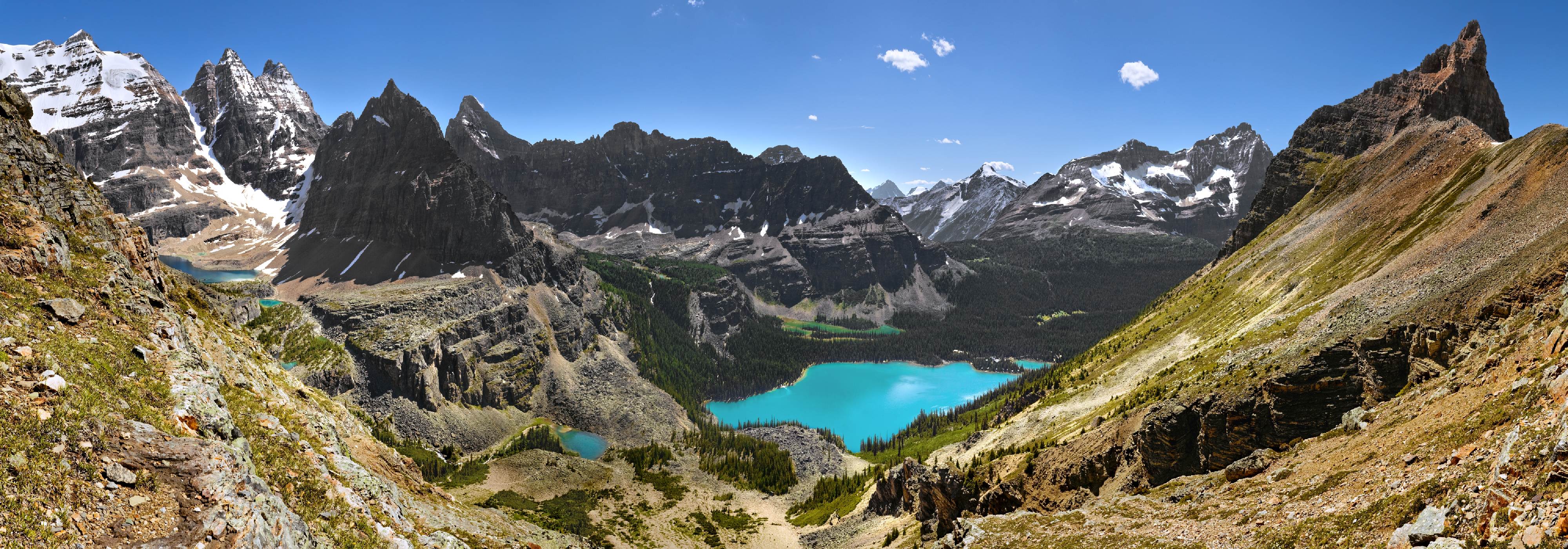 Kolem dokola -<p>Odměna za náročný výstup na Wiwaxy Gap. Nejvýraznější vodní plocha je Lake O´Hara, za ní pod horou Mount Shaffer vidíte Mary Lake. Na levé straně pod ledovcem Glacier Peak je Lake Oesa, úplně vpravo horolezci vyhledávaná špice Wiwaxy Peak – Grassi Ridge (panoramatický pohled 220 stupňů)</p>