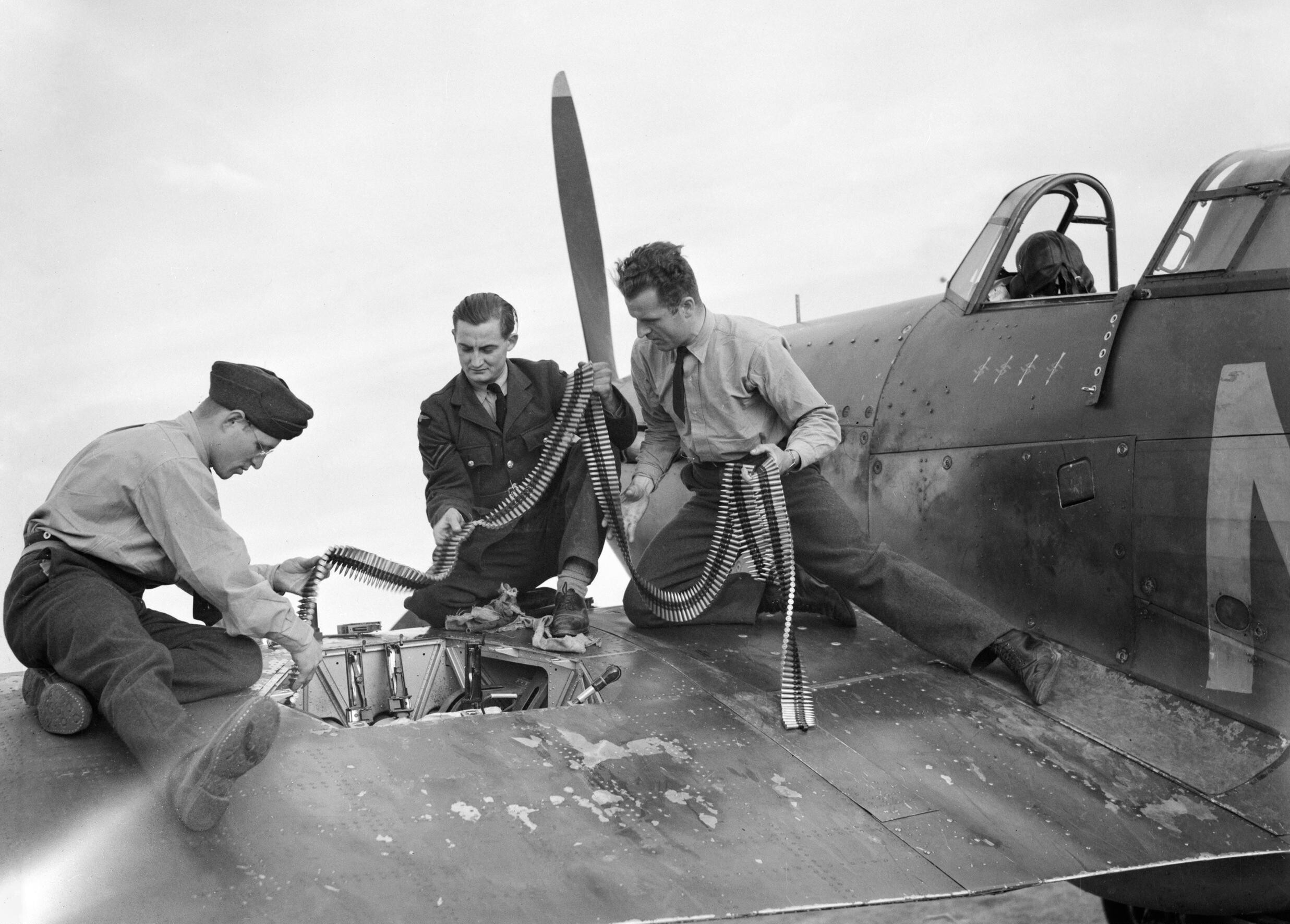 Doplňování munice -<p>Pozemní personál doplňuje v září 1940 střelivo do jedné ze stíhaček 310. čs. stíhací perutě RAF</p>
