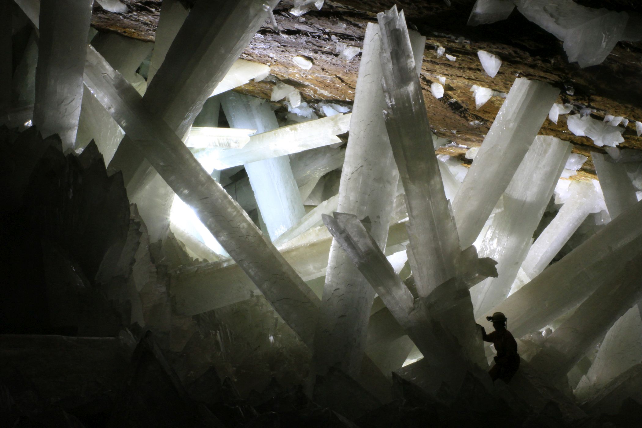 <h3>Krystaly jako sloupy</h3><p>Sopečná činnost vytvořila v mexické oblasti Naica (stát Chihuahua) jeden z nejpozoruhodnějších divů mineralogie. Celých 300 metrů pod povrchem vznikla <strong>Jeskyně krystalů (Cueva de los Cristales), jejíž hlavní síň je vyplněná obřími krystaly selenitu o hmotnosti až 55 tun. Největší dosud objevený krystal měřil na délku 12 metrů a měl průměr celé čtyři metry.</strong> Síň s obřími krystaly byla objevena teprve v roce 2000 a panují v ní pro člověka přímo extrémní podmínky: teplota 58 °C a vlhkost 98 až 99 %. Z toho důvodu <strong>je obtížně přístupná a člověk bez moderního vybavení a ochranného oděvu uvnitř nevydrží déle než zhruba deset minut</strong>. Tento přírodní skvost si tak mohlo dosud prohlédnout jen několik málo odvážlivců.</p>