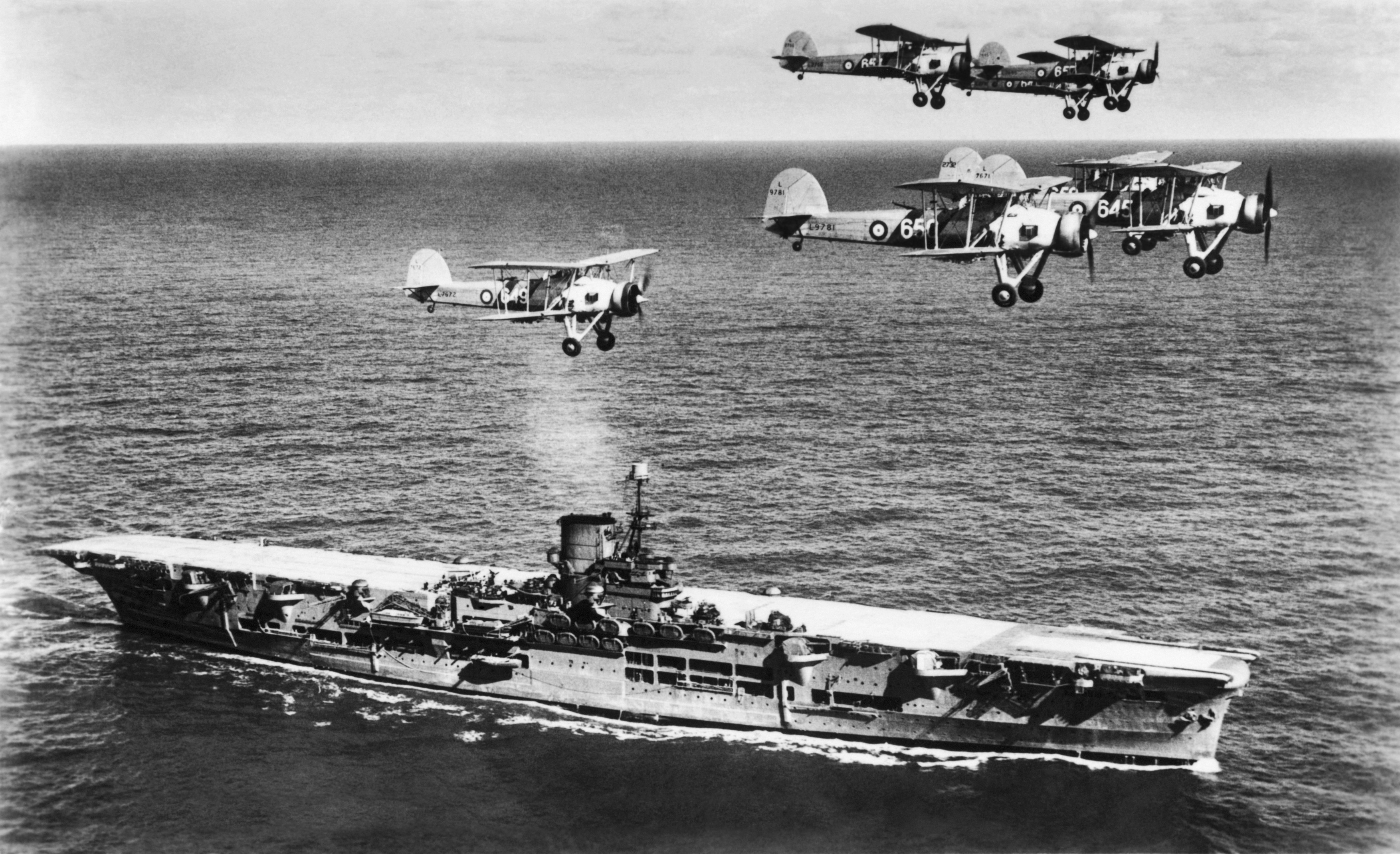 <p>Bombardéry <em>Fairey Swordfish</em> nad bitevní lodí <em>Ark Royal, </em>které německou bitevní loď zmrzačily. <em>(foto: Profimedia)</em></p>
