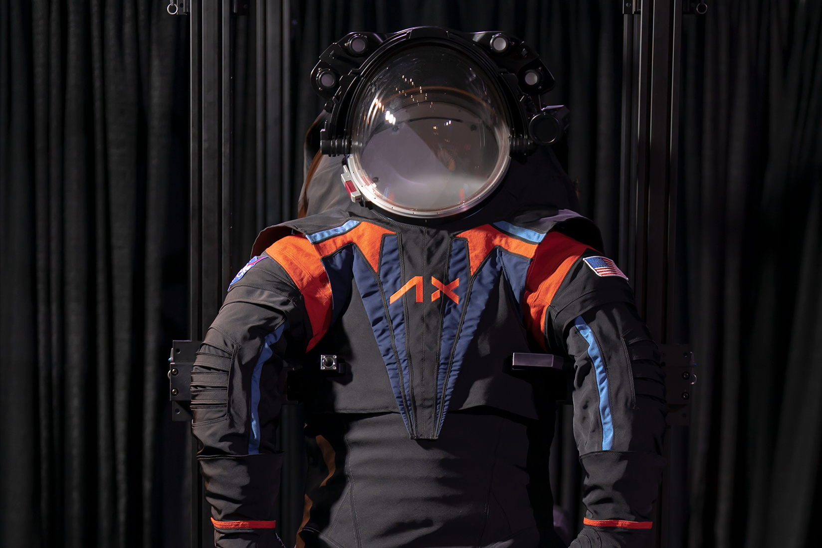 <p>Prototyp skafandru AxEMU pro měsíční misi Artemis III. Finální verze bude pravděpodobně bílá. <em>(foto: NASA/Axiom Space, CC BY 4.0)</em></p>